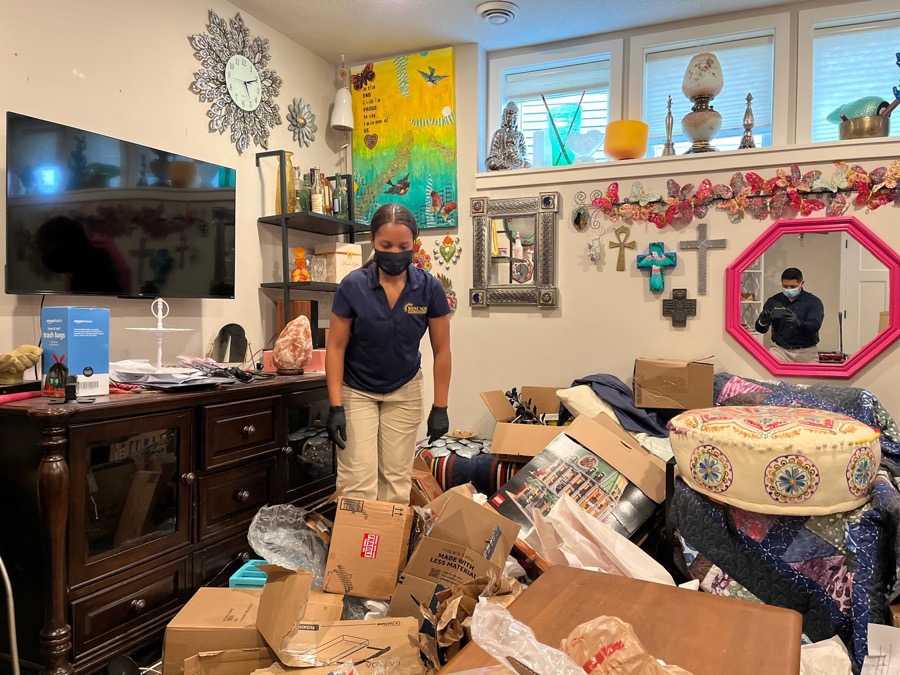 Two-person SHINENOS crew working inside a cluttered Minneapolis residence